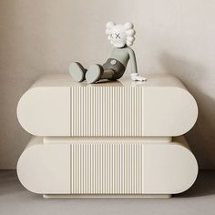 a small toy sitting on top of a white table next to a wall and floor