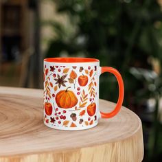 an orange and white coffee mug sitting on top of a wooden table