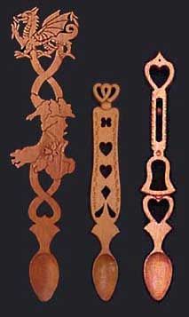 four wooden spoons with designs on them and one has a dragon in the middle