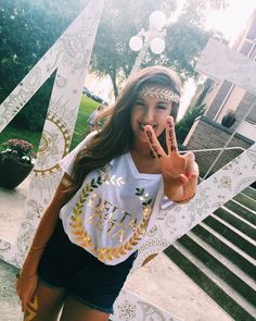 a woman with her hand up in the air while standing next to a sign that says peace