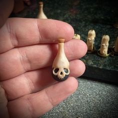 a hand is holding a small toy skull in it's left hand next to other toys