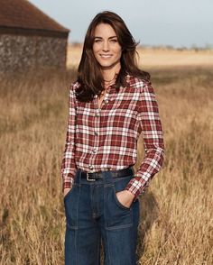 a woman standing in a field with her hands on her hips