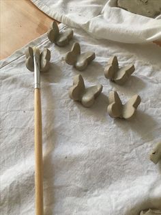 several pieces of clay sitting on top of a table next to a paintbrush and brush