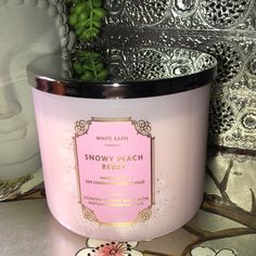 a pink candle sitting on top of a table next to a potted plant in a vase