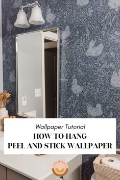 a bathroom with blue wallpaper and white vanity mirror above it is the words, how to hang peel and stick wallpaper