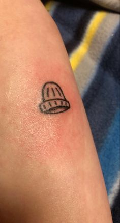 a small tattoo on the arm of a person with a hard hat on his head