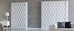 a living room with white furniture and curtains