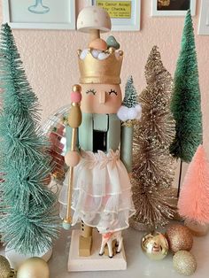 a nutcracker figurine is standing in front of christmas trees and ornaments