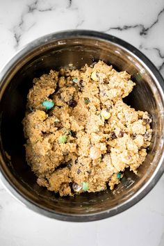 a metal bowl filled with food on top of a marble counter