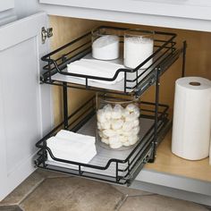 two trays holding toilet paper and rolls in a kitchen cabinet with the door open