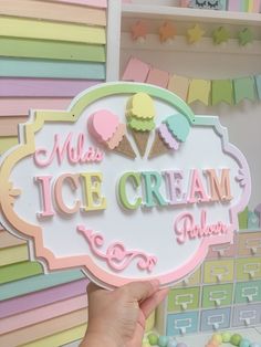 a person holding up a sign that says ice cream parlor