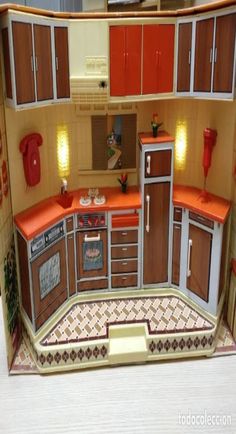 a dollhouse kitchen with orange counter tops and brown cupboards on the walls is shown