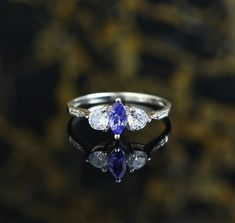 925 Sterling Silver, Tanzanite Marquise With White Topaz Round Engagement Ring, Beautiful Ring For Gift. ✔✔Metal Material-Solid 925 Sterling Silver ✔✔Stone Measurement is 3x6 MM ✔✔Natural Tanzanite And Side White Topaz Is Used ✔✔0.25-0.30 CT Approx. Weight Of Stone ✔✔ Weight Of The Ring Is 1.10 Grams December Birthstone ✔✔Please note that there Can be slight variations in stone texture and color shades in the actual product that you receive. Stone quality or grade will be same. Because We Use Na Silver Marquise Cut Blue Topaz Ring, Classic Silver Tanzanite Diamond Ring, Silver Tanzanite Ring With Brilliant Cut, Silver Tanzanite Hallmarked Rings, Silver Tanzanite Multi-stone Rings, Round Engagement Rings, Natural Tanzanite, Stone Texture, December Birthstone