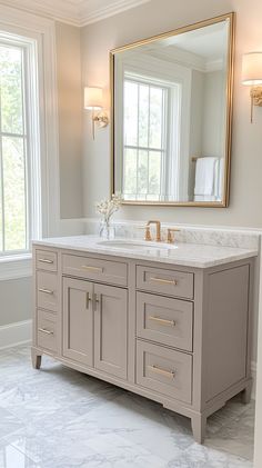 a bathroom vanity with two sinks and a large mirror on the wall above it in front of a window