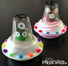 two plastic cups that have been decorated to look like an alien ship with eyes and nose