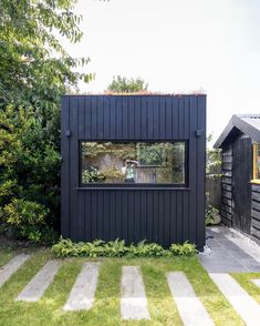 a small black house with a large window