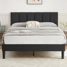 a black bed frame with white sheets and pillows on it, in a bedroom setting