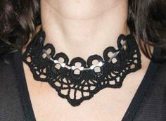 a woman wearing a black crochet necklace with white beads on her collarline