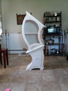 a large white book shelf sitting in the middle of a living room