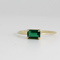 This beautiful East West Emerald Gold Ring was handmade in Melt'm Jewelry Design Studio in California using 14k solid yellow gold band and 6x4mm emerald cut lab grown emerald stone. Emerald is featuring in 14k gold prong setting. DETAILS ABOUT THE RING, MATERIAL AND STONES Ring Band: 14K solid gold Ring Band size: 1.2 mm thick Gemstone: Lab grown Emerald Emerald size: 6mm x 4mm emerald cut Yellow gold or white gold options available from drop down menu. It is a great birthday gift for your speci Emerald Cut 14k Gold Jewelry, 14k Gold Emerald Cut Emerald Ring For May Birthstone, 14k Gold Emerald Cut Rings For May Birthstone, Rectangular Solitaire Emerald Jewelry, 14k Gold Baguette Cut Emerald Ring For May Birthstone, 14k Gold Emerald Ring Radiant Cut For Gift, Minimalist Emerald Cut Emerald Ring For May, 14k Gold Emerald Ring With Baguette Cut, 14k Gold Radiant Cut Emerald Ring Gift