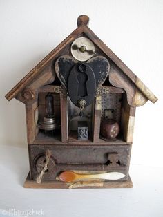 an old wooden cuckoo clock with keys and other items