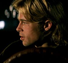 a close up of a person in the dark with a steering wheel behind his head