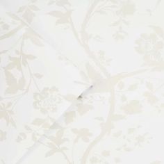 the wallpaper is white and has floral designs on it, as well as a piece of paper