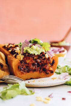 a taco sandwich on a plate with a fork next to it and some lettuce