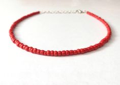 This red bead necklace is 100% handmade with beautiful glass seed beads. It can be made either 14, 16, 18, or 20 inches long, and each necklace comes with additional extender chain, making it easily adjustable. This necklace goes great with so many outfits- dress it up for a fancier event, or wear it with jeans and a t-shirt. It also makes a simple yet amazing gift for a family member, friend or loved one! Red Beach Choker Jewelry, Handmade Red Beaded Choker Necklace, Handmade Adjustable Red Choker, Adjustable Red Choker With Tiny Beads, Adjustable Handmade Red Choker, Beach Red Beaded Choker, Red Bead Choker For Festivals, Red Beaded Choker As Gift, Red Beaded Choker Necklace As Gift