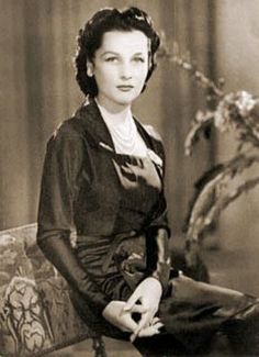 an old photo of a woman sitting on a couch