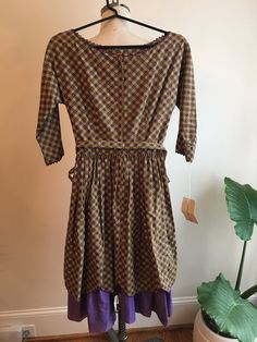 "The details on this 1950s vintage square dance/day dress are out of this world. Metal zipper. Tiled flower print. Tan, purple, white. Scalloped hem + rick rack edge. Fabric covered buttons. Fabulous kimono sleeve. Self fabric covered Hy-Tek belt. The wide hem on the dress AND the lining scream quality and attention to detail. Beautiful condition. Size XS. Perfect as a day dress. Garden party dress. Western style country dress. Square dance dress. Assuming this is 100% cotton fabric. Measurement Fitted A-line Vintage Prairie Dress, Vintage Purple A-line Dress, Vintage Cotton Fit And Flare Dress, Purple Fitted Vintage Dress, Vintage Fitted A-line Prairie Dress, Retro Fitted Prairie Dress With Square Neck, Fitted Retro Prairie Dress With Square Neck, Purple Vintage Dress For Spring, Retro Fitted Prairie Dress For Garden Party