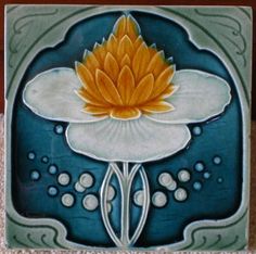 a ceramic tile with an orange and white flower on it