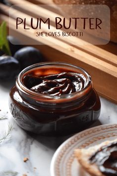 a jar of jam sitting on top of a table next to blueberries and bread