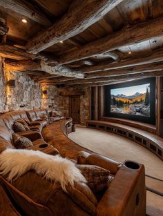 a home theater with leather couches and stone walls