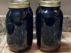 two mason jars sitting on top of a wooden cutting board