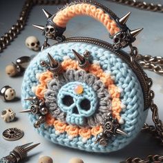 a crocheted skull purse with spikes on the handle and chain attached to it