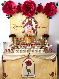 a beauty and the beast themed dessert table with red roses on it's head