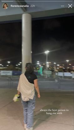 a woman walking down the street at night