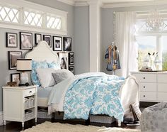 a bedroom with white furniture and pictures on the wall behind the bed is decorated in blue and white