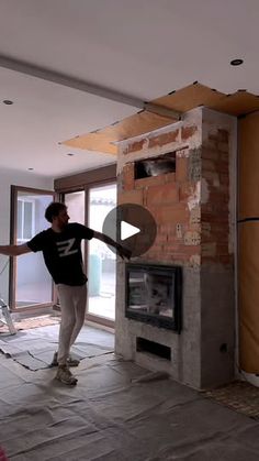 a man standing in front of a fire place next to a wall with torn up walls