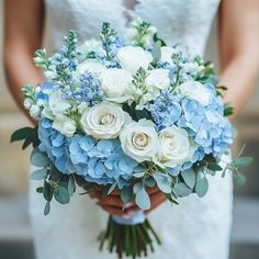 a bride holding a bouquet of blue and white flowers