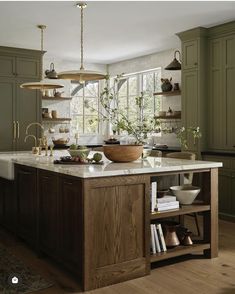 a large kitchen with green cabinets and white counter tops, an island in the middle