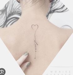 the back of a woman's neck with a heart shaped balloon tattoo on it