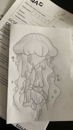 a drawing of a jellyfish on top of some sheets of paper next to each other