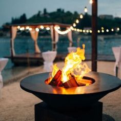 a fire pit sitting on top of a sandy beach