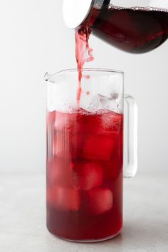 red liquid being poured into a glass pitcher