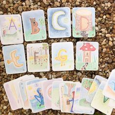 there are many cards on the ground with letters and animals in them, all laid out next to each other