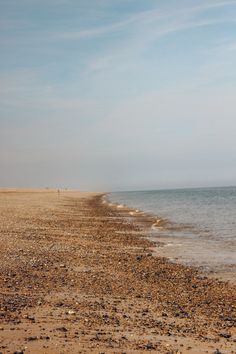 the beach is littered with rocks and pebbles