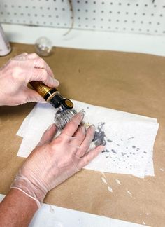 a person is using a brush to paint the paper