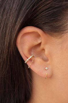 a woman's ear is shown with two small beads on the end of it